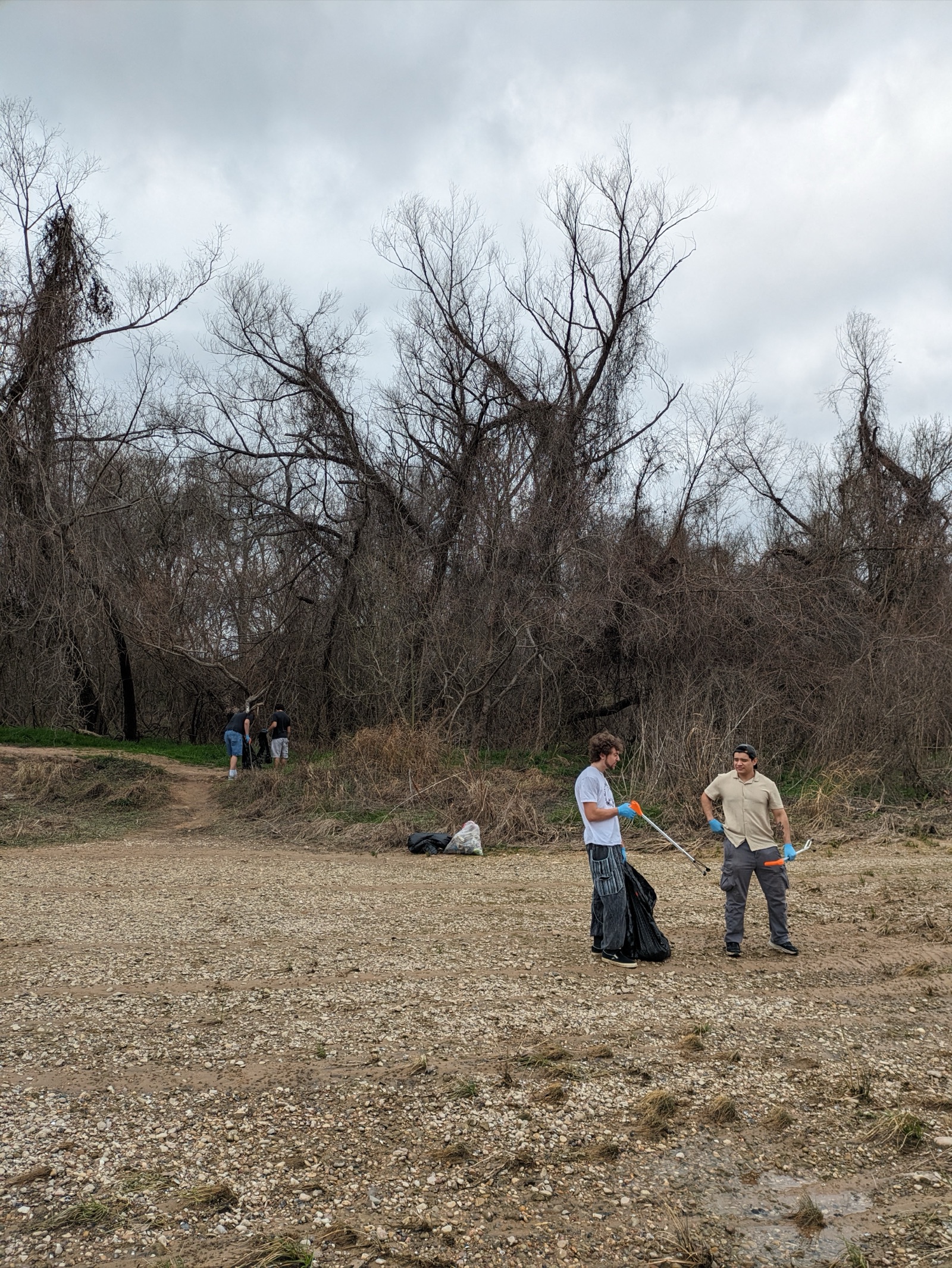 Two students with trash grabbers at a Riverside Secret Beach cleanup